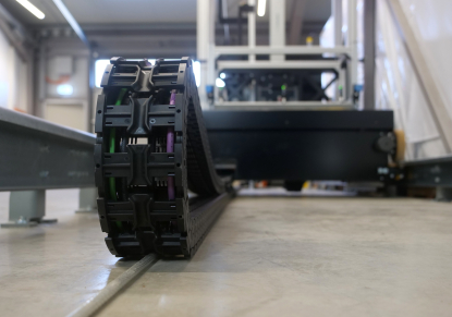 Transelevador para almacenes automatizados equipado con cadena portacables